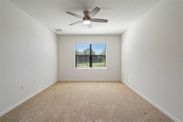 carpeted spare room featuring a textured ceiling and ceiling fan