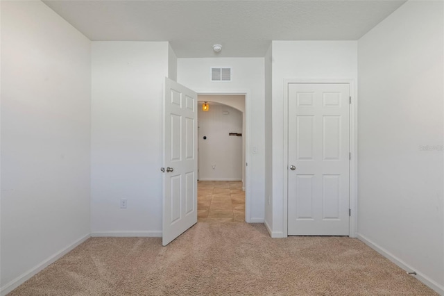 unfurnished bedroom with light colored carpet