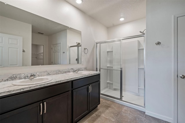 bathroom featuring vanity, a textured ceiling, and walk in shower