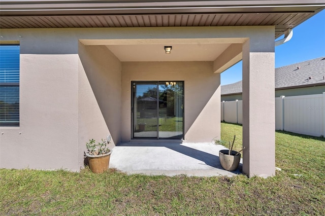 property entrance with a yard and a patio