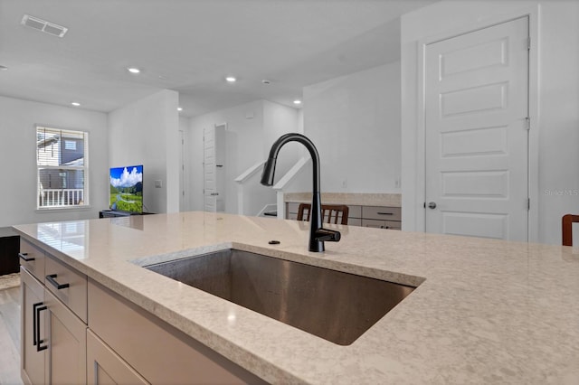 kitchen with light stone countertops and sink