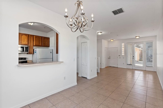 interior space featuring pendant lighting, light tile patterned floors, and stainless steel appliances