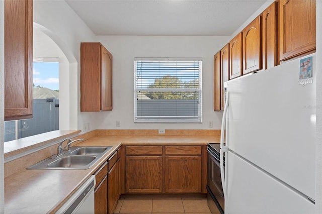 kitchen featuring sink, light tile patterned floors, and white appliances