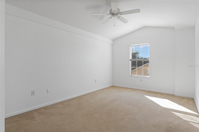 empty room featuring light carpet, lofted ceiling, and ceiling fan