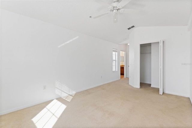 unfurnished bedroom featuring lofted ceiling, light carpet, a closet, and ceiling fan