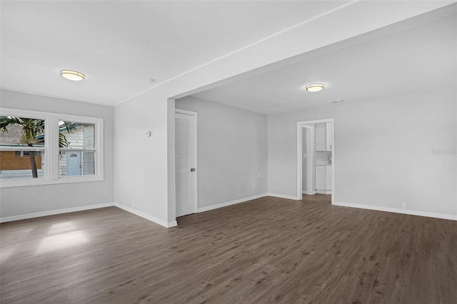 unfurnished room with dark wood-type flooring