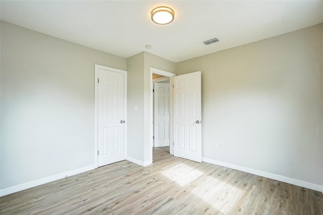 unfurnished bedroom with a closet and light wood-type flooring