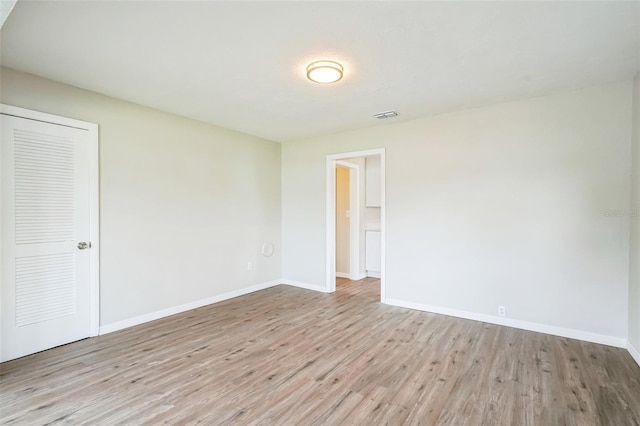 unfurnished bedroom with light hardwood / wood-style floors and a closet