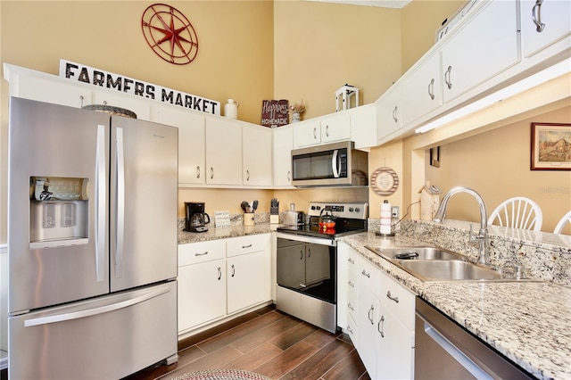 kitchen with sink, white cabinets, light stone countertops, and appliances with stainless steel finishes