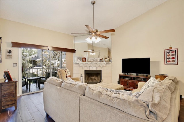 living room featuring ceiling fan, dark wood-type flooring, lofted ceiling, and a fireplace