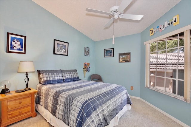 bedroom featuring a textured ceiling, light colored carpet, vaulted ceiling, and ceiling fan