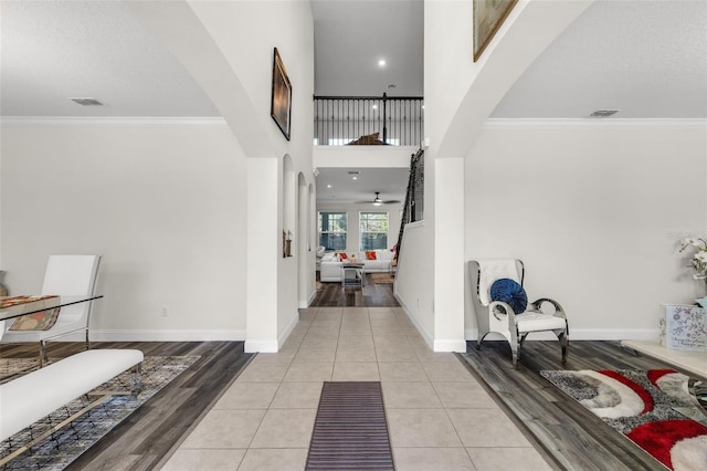 hall with crown molding and light tile patterned floors