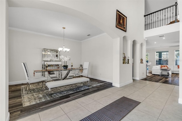 tiled dining area with an inviting chandelier and ornamental molding