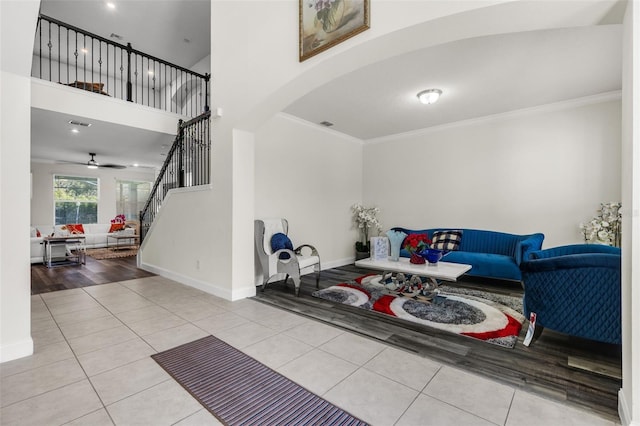 interior space with ceiling fan, light tile patterned floors, and crown molding