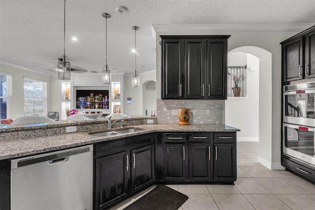 kitchen featuring sink, ornamental molding, backsplash, and appliances with stainless steel finishes