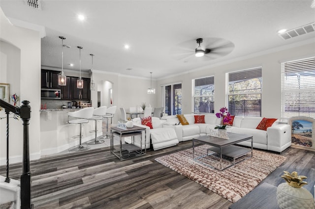 living room with ceiling fan, dark hardwood / wood-style flooring, and ornamental molding