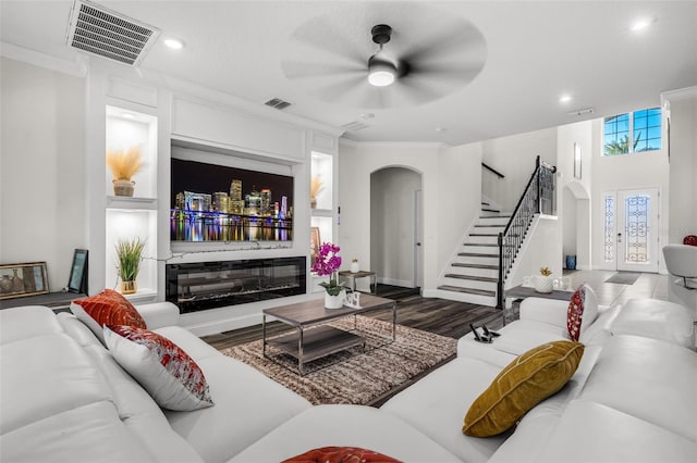 living room with hardwood / wood-style flooring, ceiling fan, and ornamental molding