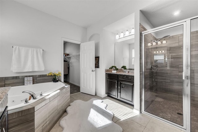 bathroom with tile patterned floors, vanity, and separate shower and tub