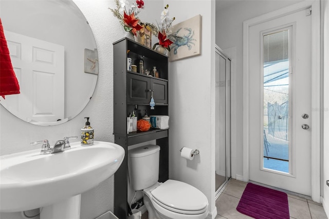 bathroom featuring toilet, tile patterned flooring, plenty of natural light, and sink