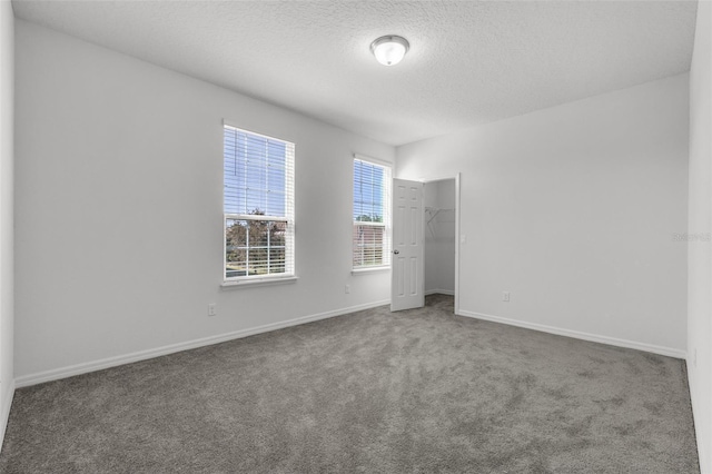 carpeted empty room with a textured ceiling