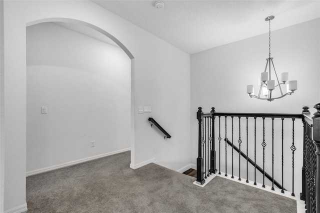 stairs featuring carpet, vaulted ceiling, and a notable chandelier