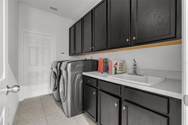 clothes washing area featuring light tile patterned flooring, cabinets, separate washer and dryer, and sink