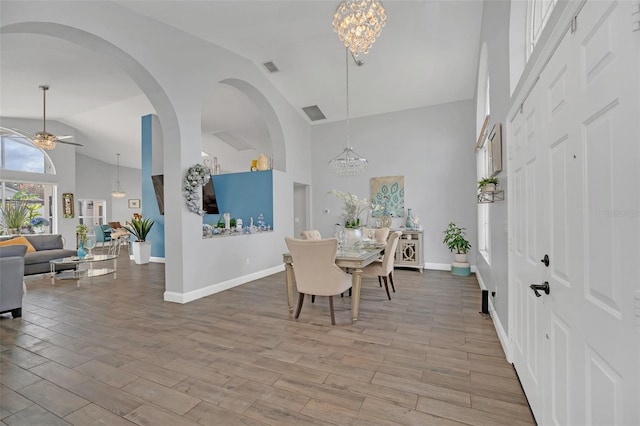 dining area with lofted ceiling and ceiling fan with notable chandelier