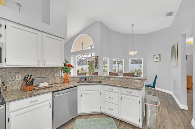 kitchen featuring stone counters, white cabinetry, stainless steel dishwasher, and sink