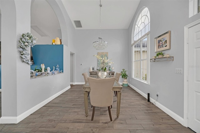 dining space featuring hardwood / wood-style flooring and a chandelier