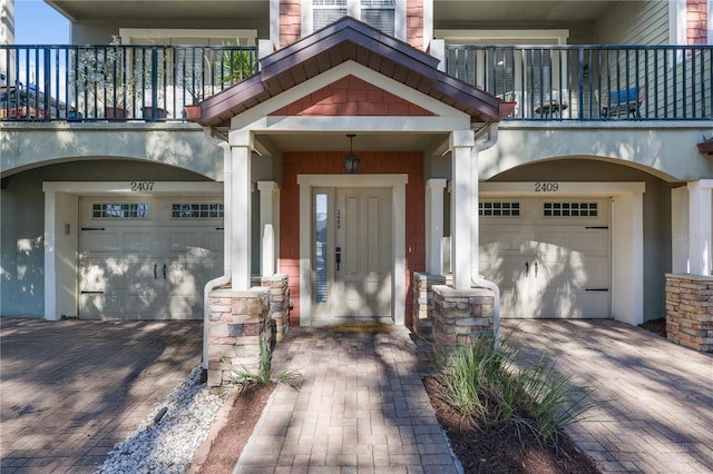 property entrance featuring a garage and a balcony