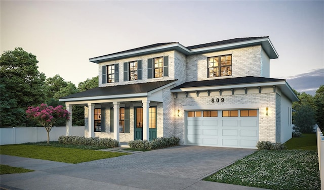 view of front of home featuring a garage, a front yard, and covered porch