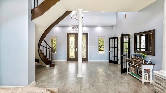 entrance foyer featuring an inviting chandelier, french doors, and a high ceiling