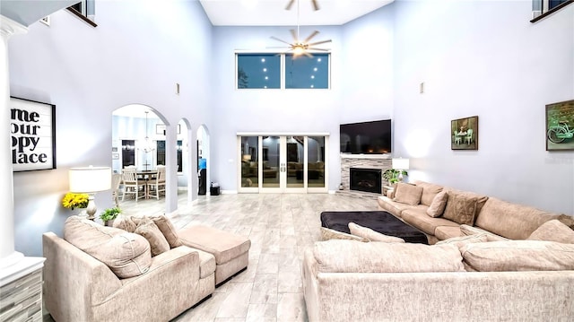 living room with decorative columns, light hardwood / wood-style floors, and ceiling fan