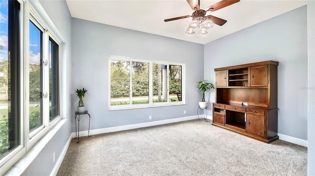 unfurnished living room featuring ceiling fan and carpet