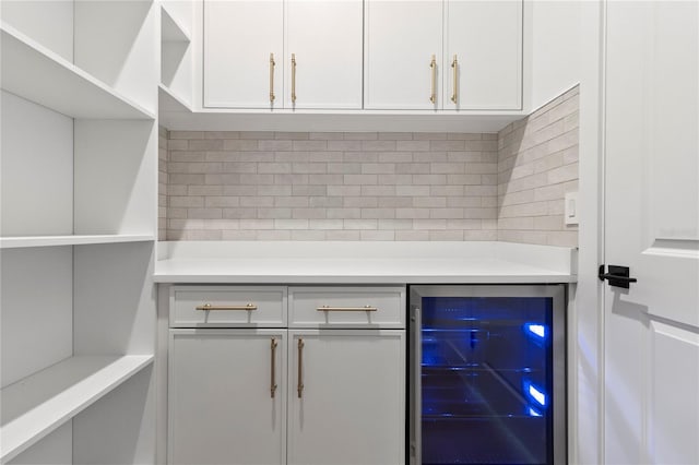 bar featuring white cabinets, wine cooler, and backsplash