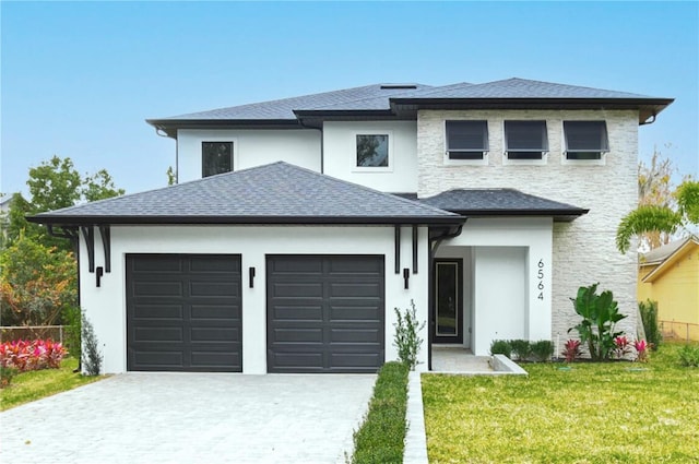 prairie-style house featuring a front lawn and a garage