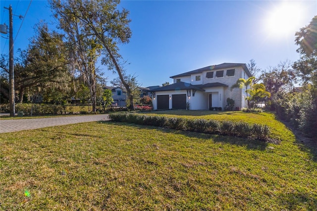 view of front of property with a garage and a front lawn