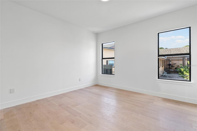 spare room featuring plenty of natural light and light hardwood / wood-style floors