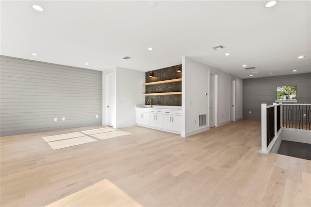 living room with wood walls and light hardwood / wood-style flooring