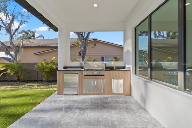 view of patio with area for grilling, an outdoor kitchen, and sink