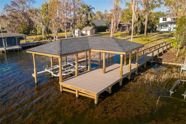 view of dock featuring a water view and a yard