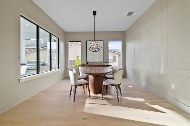 dining room featuring a notable chandelier, light hardwood / wood-style floors, and a wealth of natural light