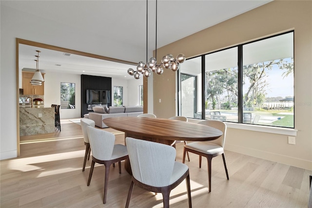 dining space featuring light hardwood / wood-style floors, a notable chandelier, and a wealth of natural light