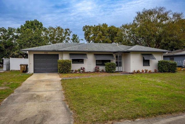 ranch-style home featuring a garage and a front lawn