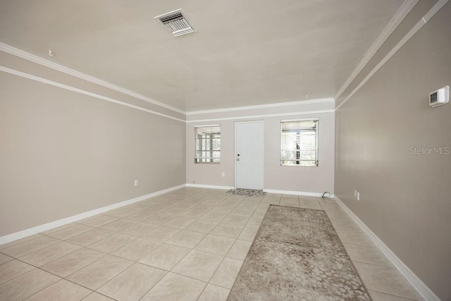 empty room with light tile patterned floors and crown molding