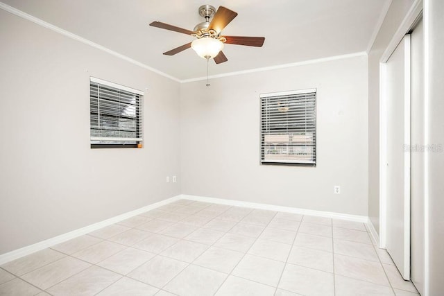 tiled spare room featuring ceiling fan and ornamental molding