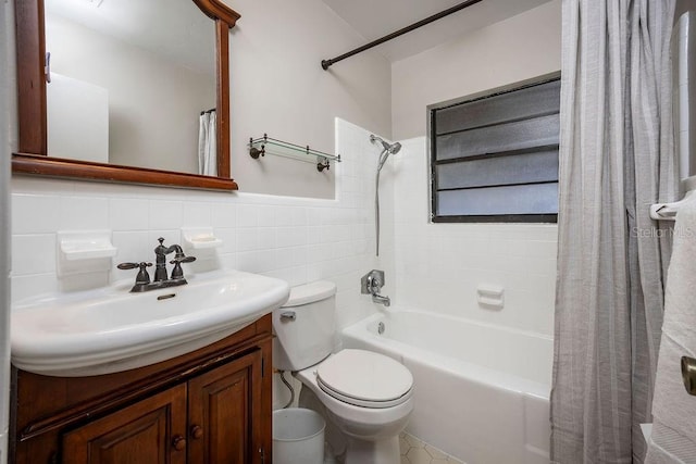 full bathroom with shower / bath combo, vanity, toilet, and tile walls