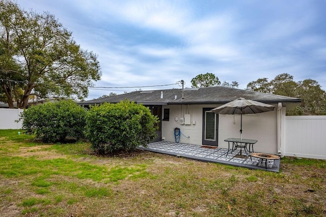 back of property with a patio and a lawn