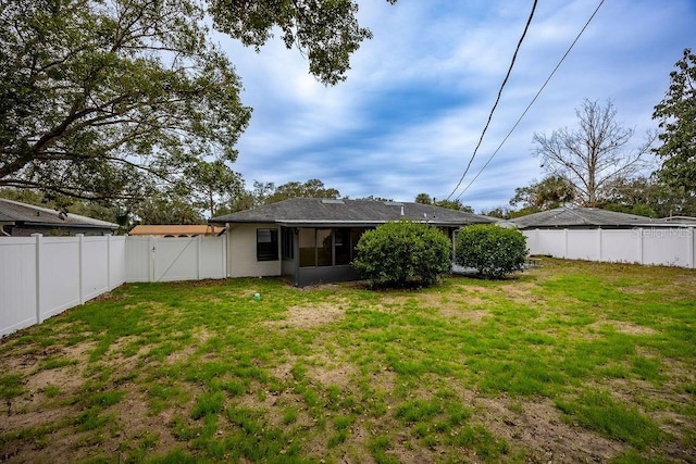 back of property featuring a sunroom and a yard