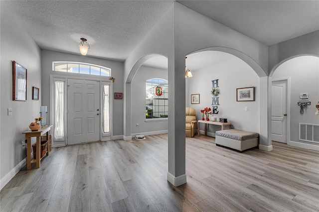 foyer with a textured ceiling and light hardwood / wood-style floors